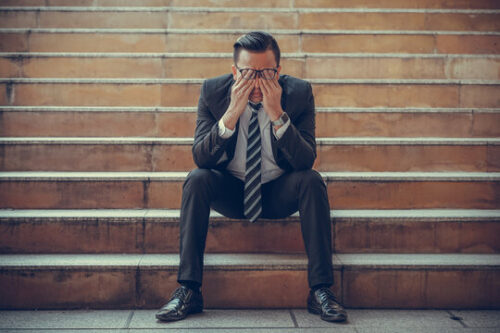 man in suit sad on steps