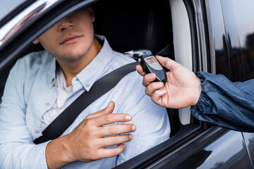 police officer handing man breathalyzer test